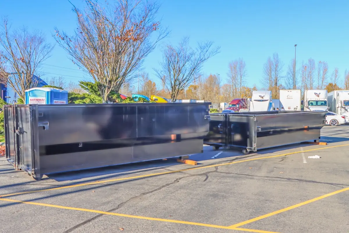 Professional dumpster rental service with roll-off container on residential driveway in Busti